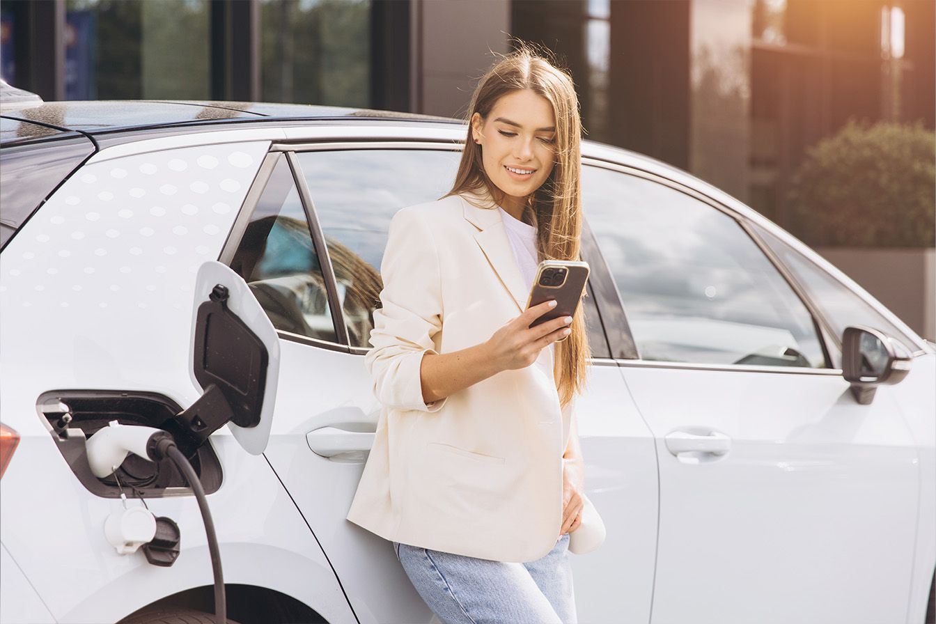 Une femme attendant la recharge de son véhicule électrique.jpg