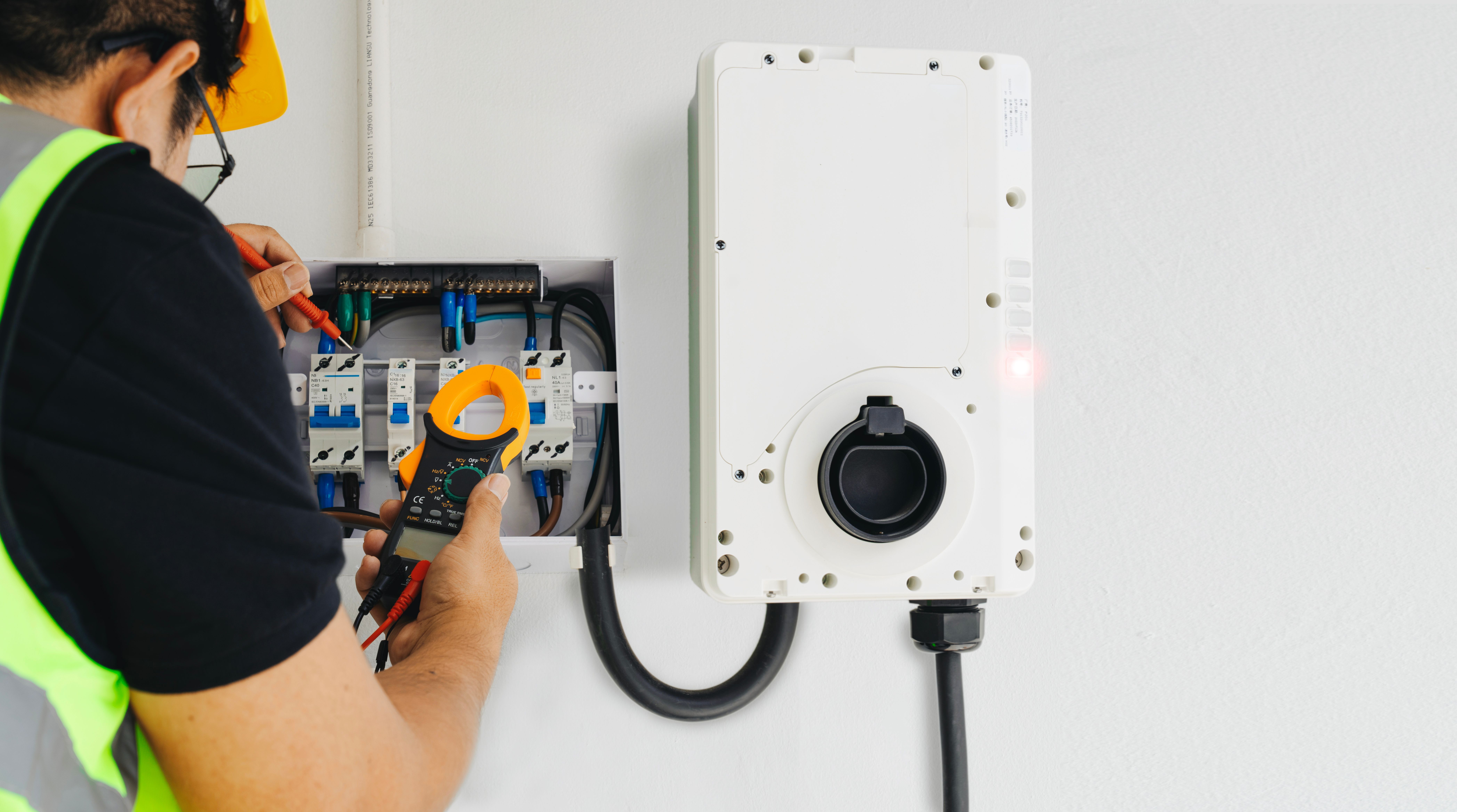 Technicien qui mesure l'ampérage de la borne de recharge