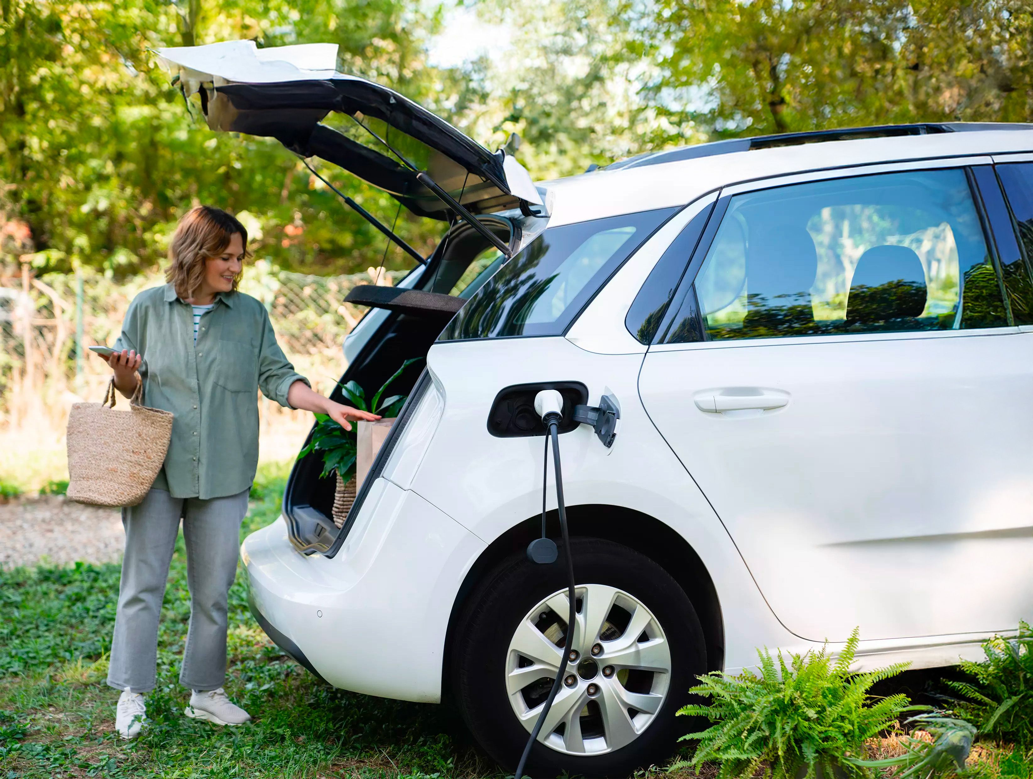 Femme qui charge sa voiture électrique