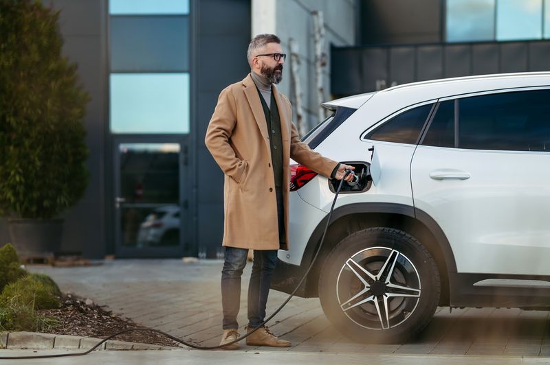 Employé utilisant des bornes de recharge sur le parking d'entreprise
