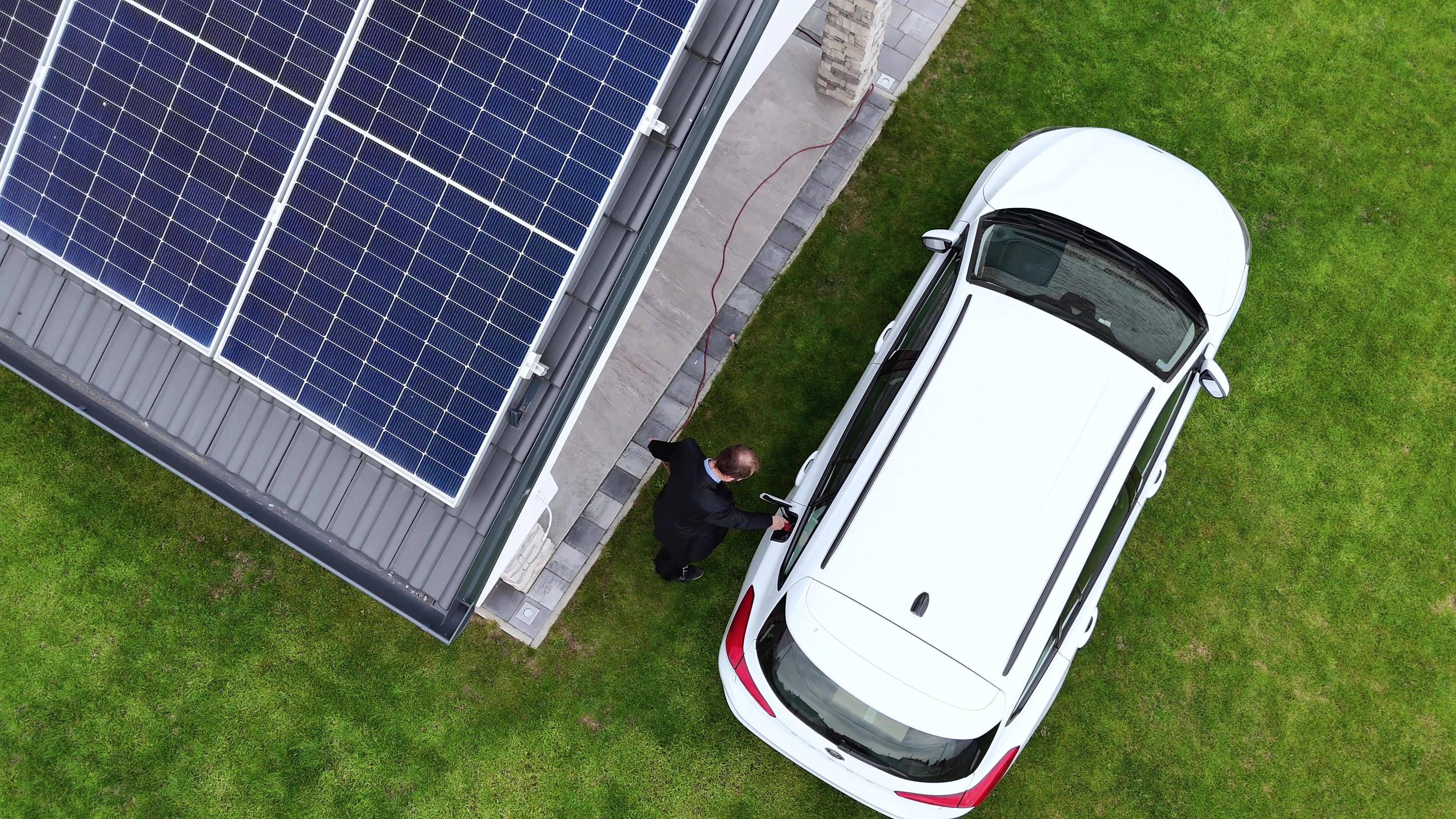Maison moderne avec panneaux solaires et borne de recharge connectée