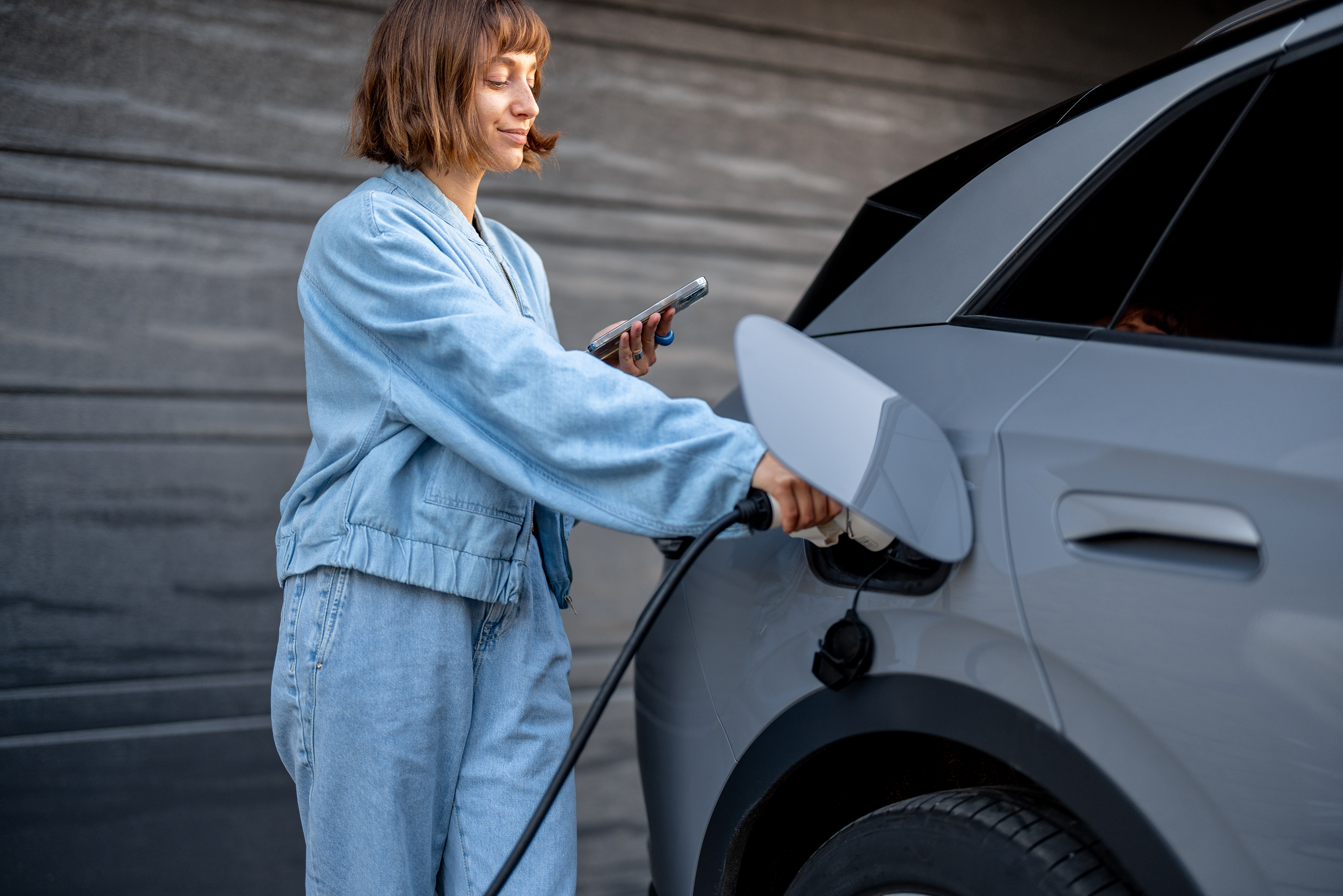 Donna ricarica auto elettrica