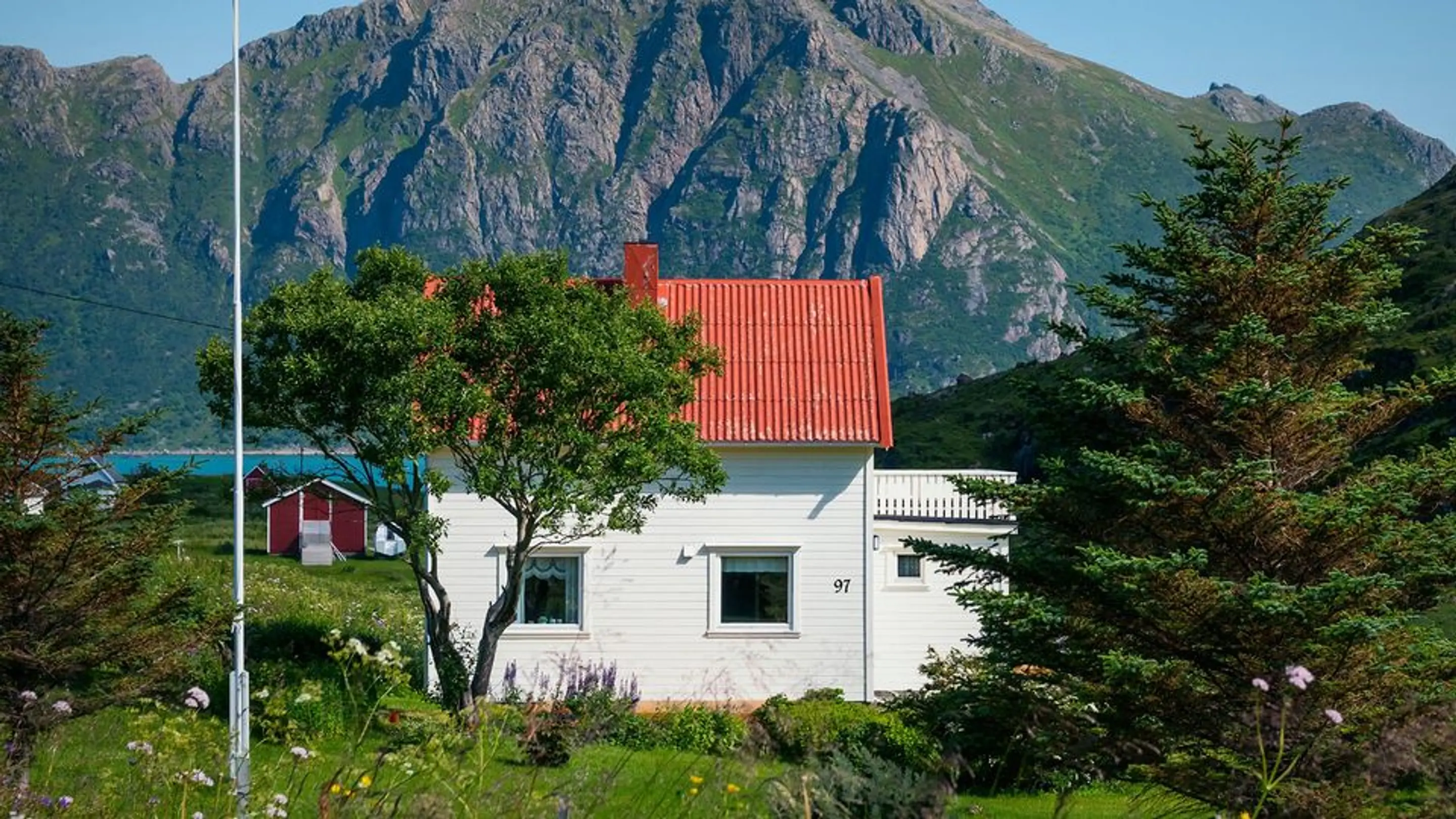 Bilde av et hvitt hus med et stort fjell i bakgrunnen.