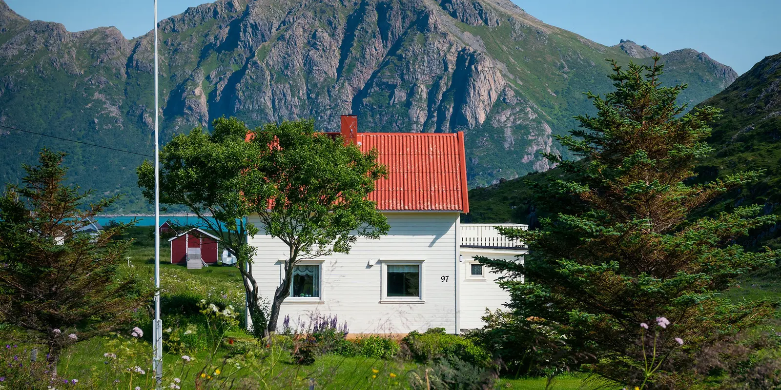 Bilde av et hvitt hus med et stort fjell i bakgrunnen.