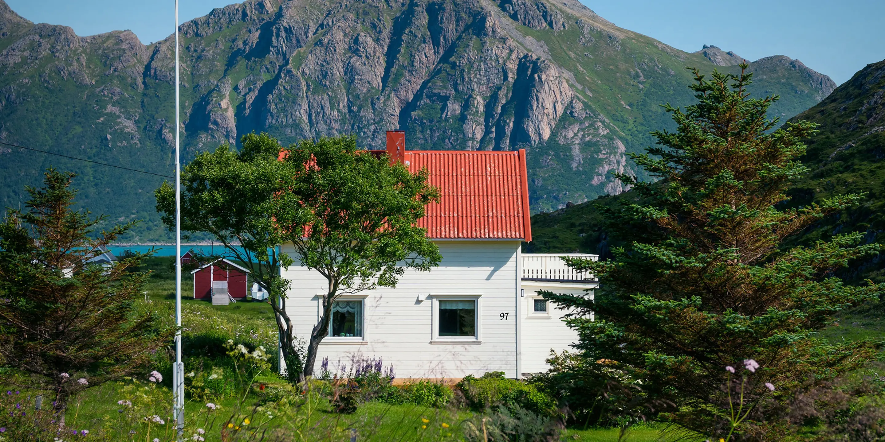 Bilde av et hvitt hus med et stort fjell i bakgrunnen.