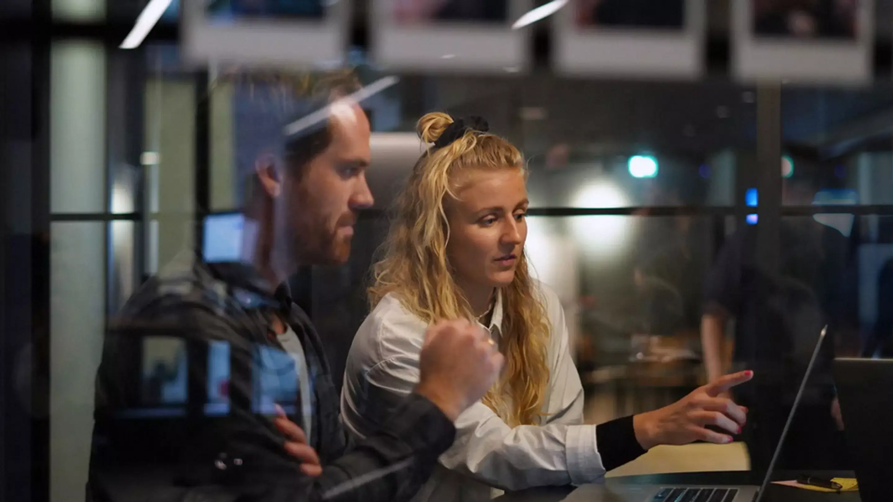 Bilde av ansatte i Nettbureau som peker på en datamaskin