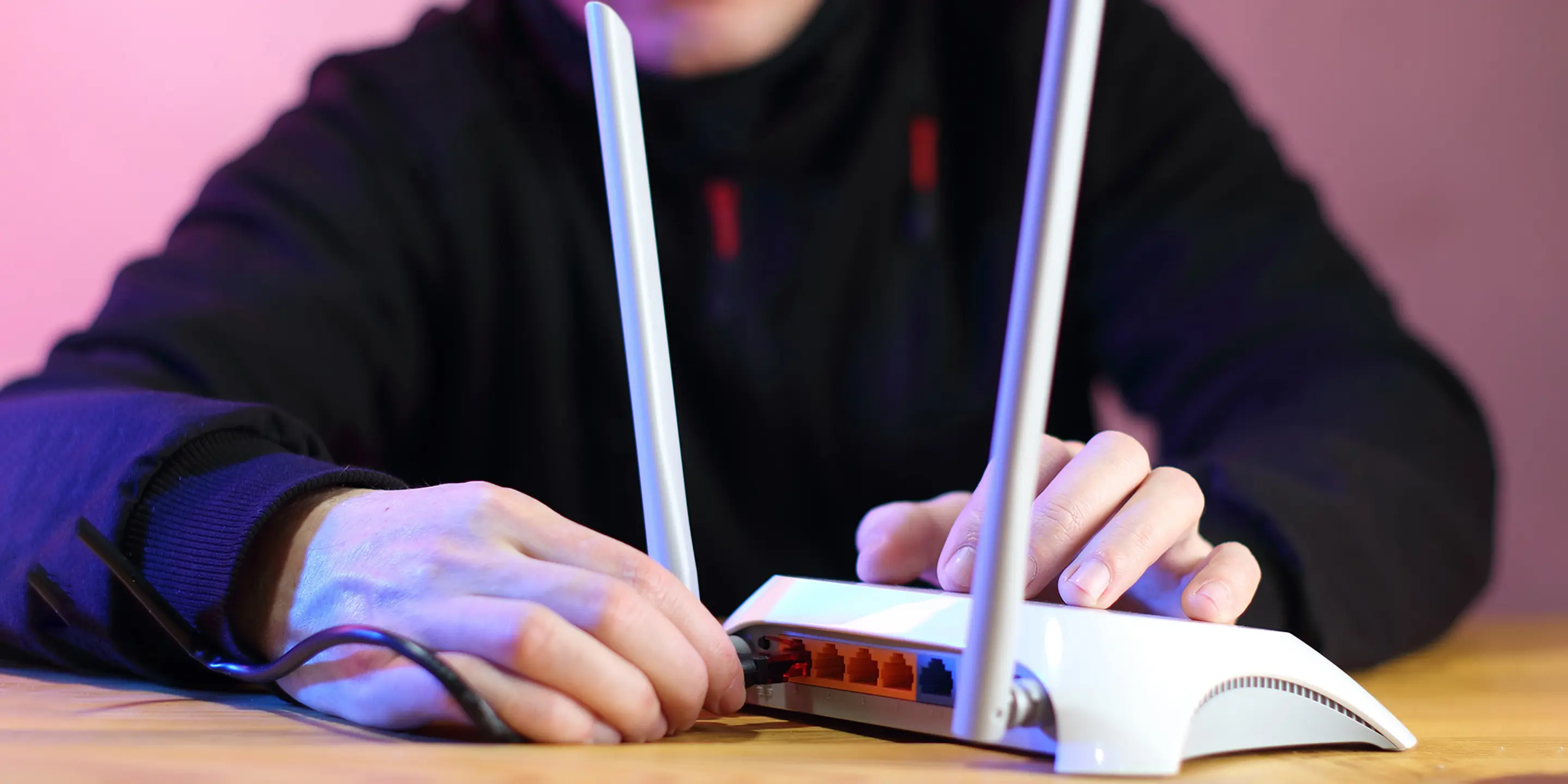 Nærbilde av en person som plugger i strømkontakten i en router.