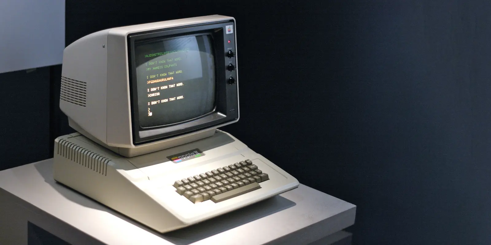Bilde av en Apple II datamaskin på et lite bord.