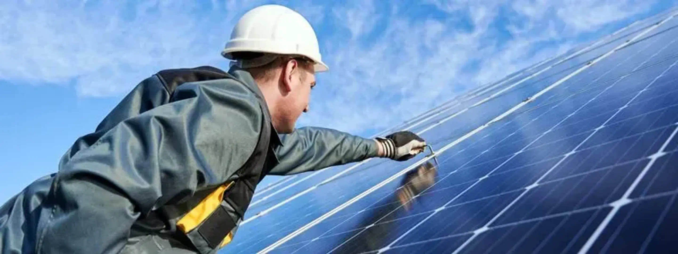 Solcellemontør der er ved at installere solceller.