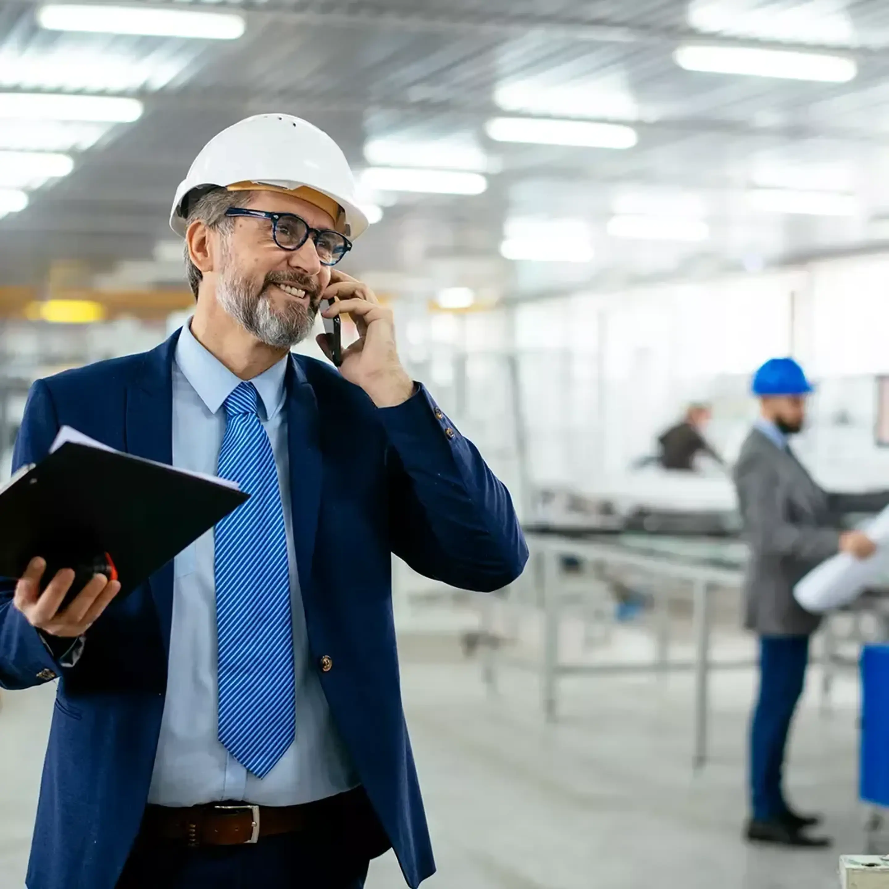 Man i industrilokal pratar i telefon.