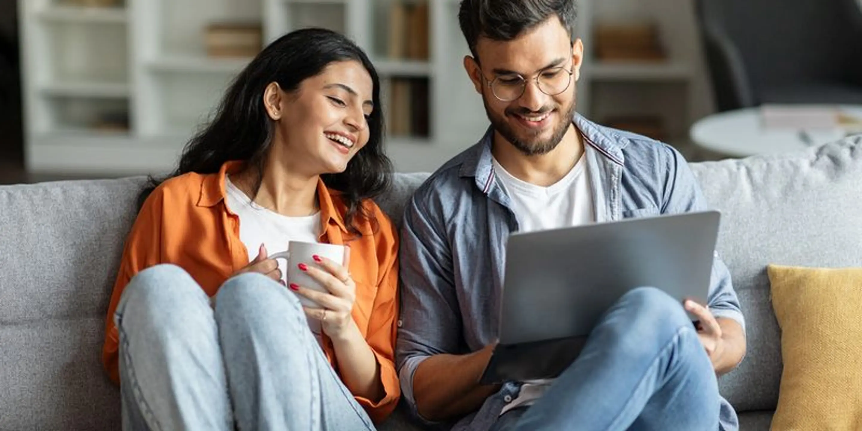 Dame og mann som ser på en laptop