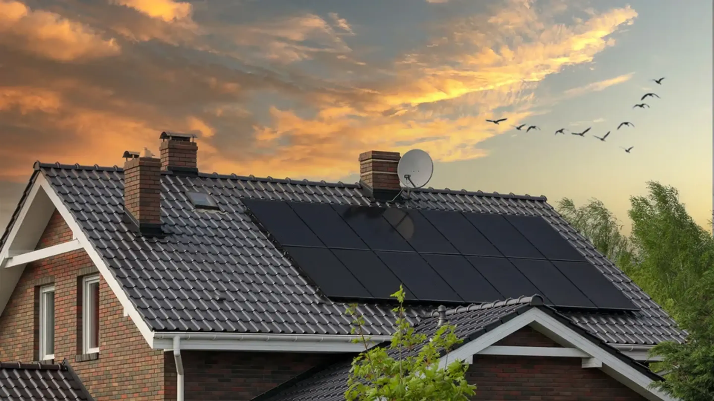 Solceller på taget af et typisk dansk hus med flot himmel i baggrunden