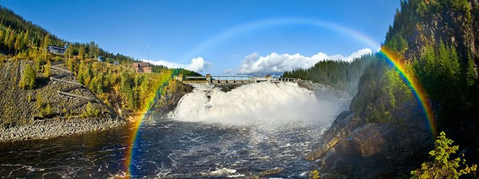 Et bilde av en demning med en regnbue over.