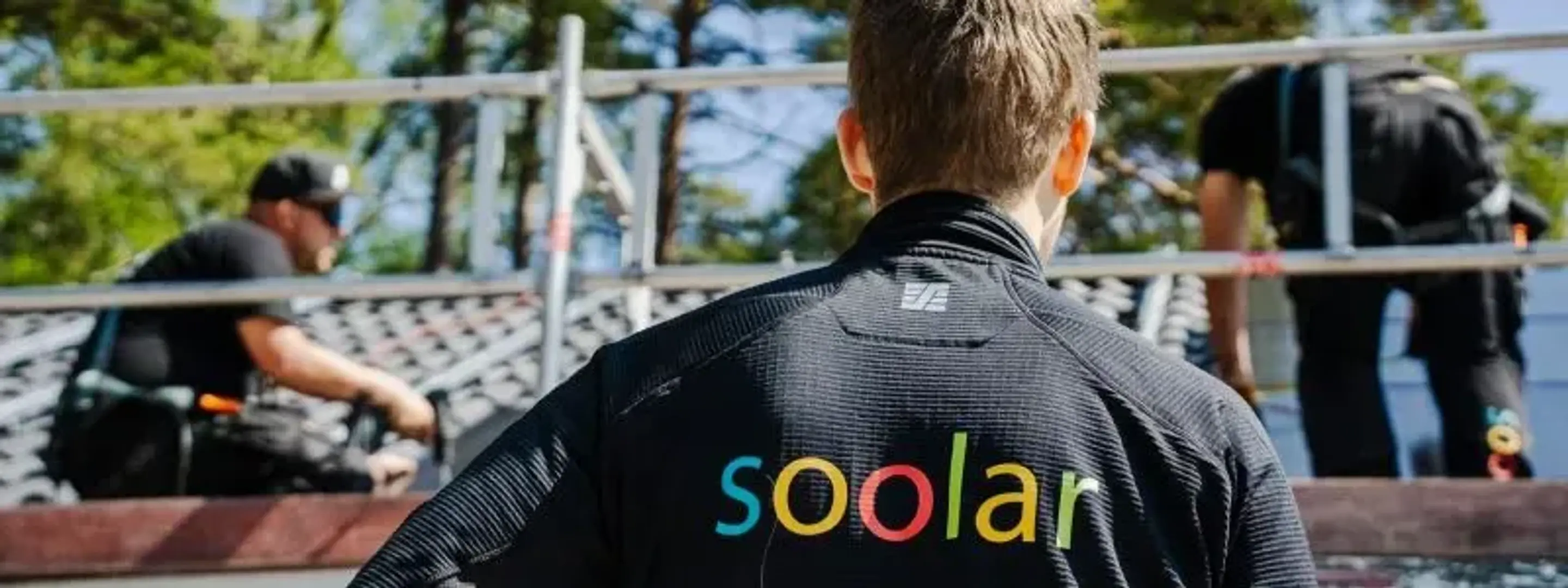 Anställda från Soolar installerar solceller på ett tak.