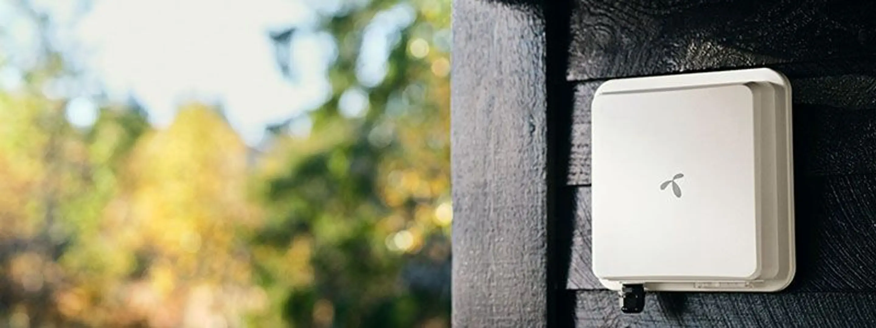 Nærbilde av en veggmontert utendørsantenne for trådløst bredbånd med telenor logoen på.