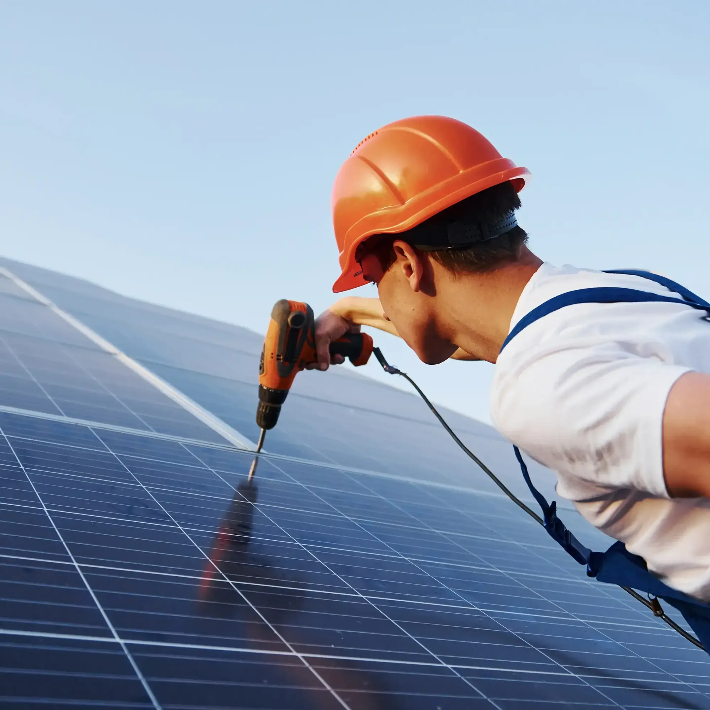 Ung hantverkare borrar i solceller.