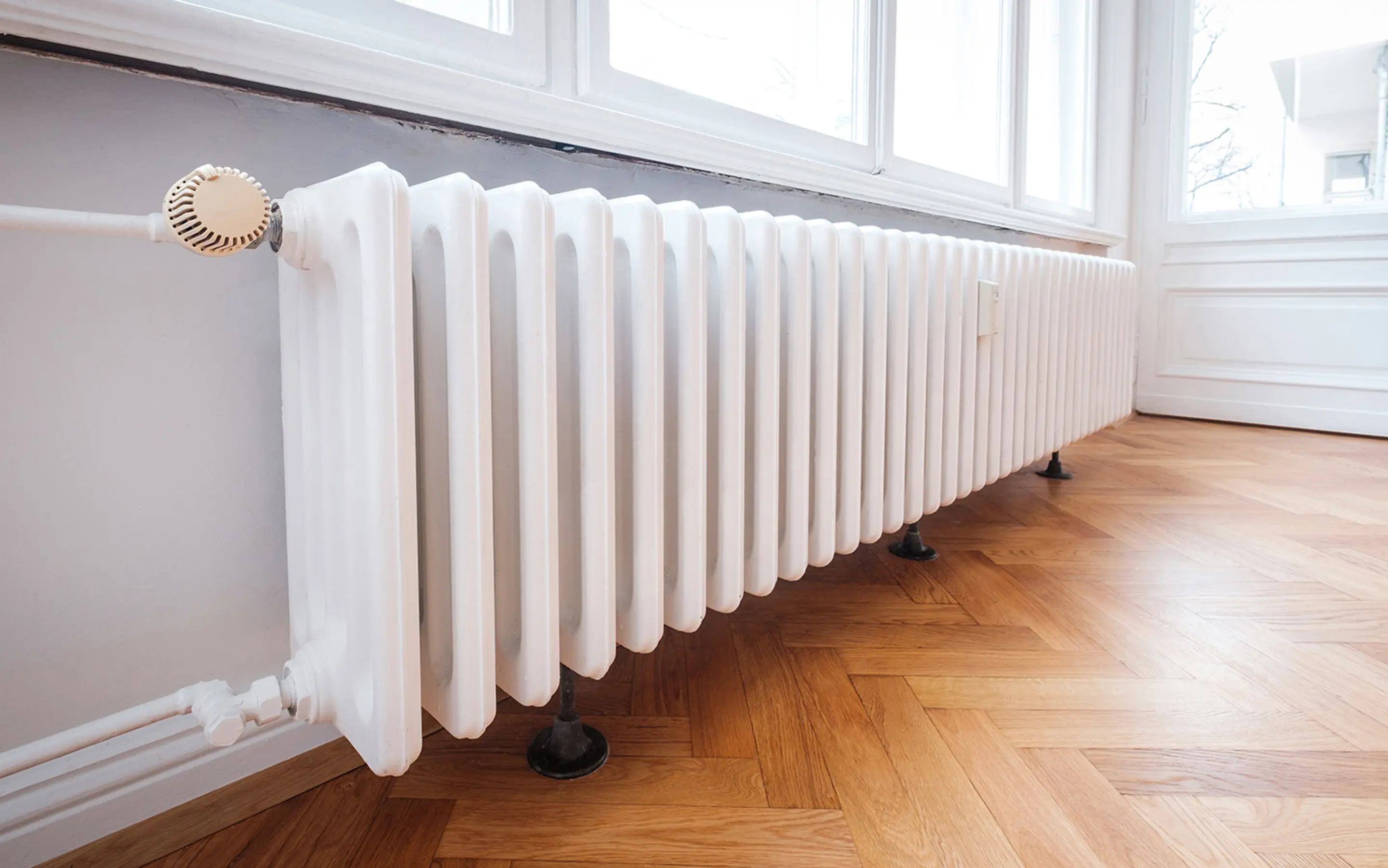 Bilde av en radiator under et vindu.