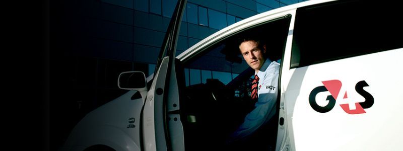 Mand i G4S-uniform stiger ud af en bil.