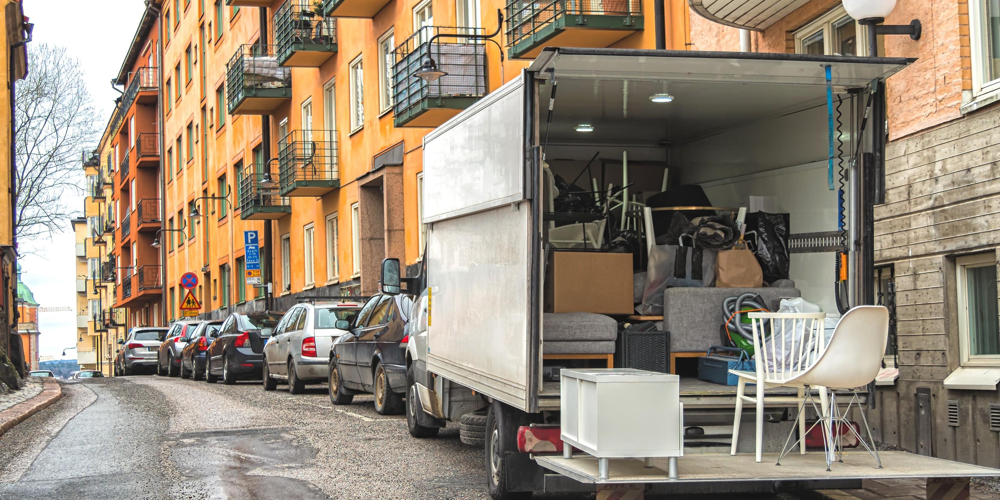 En flyttbil står på gatan, fylld av någons bohag.