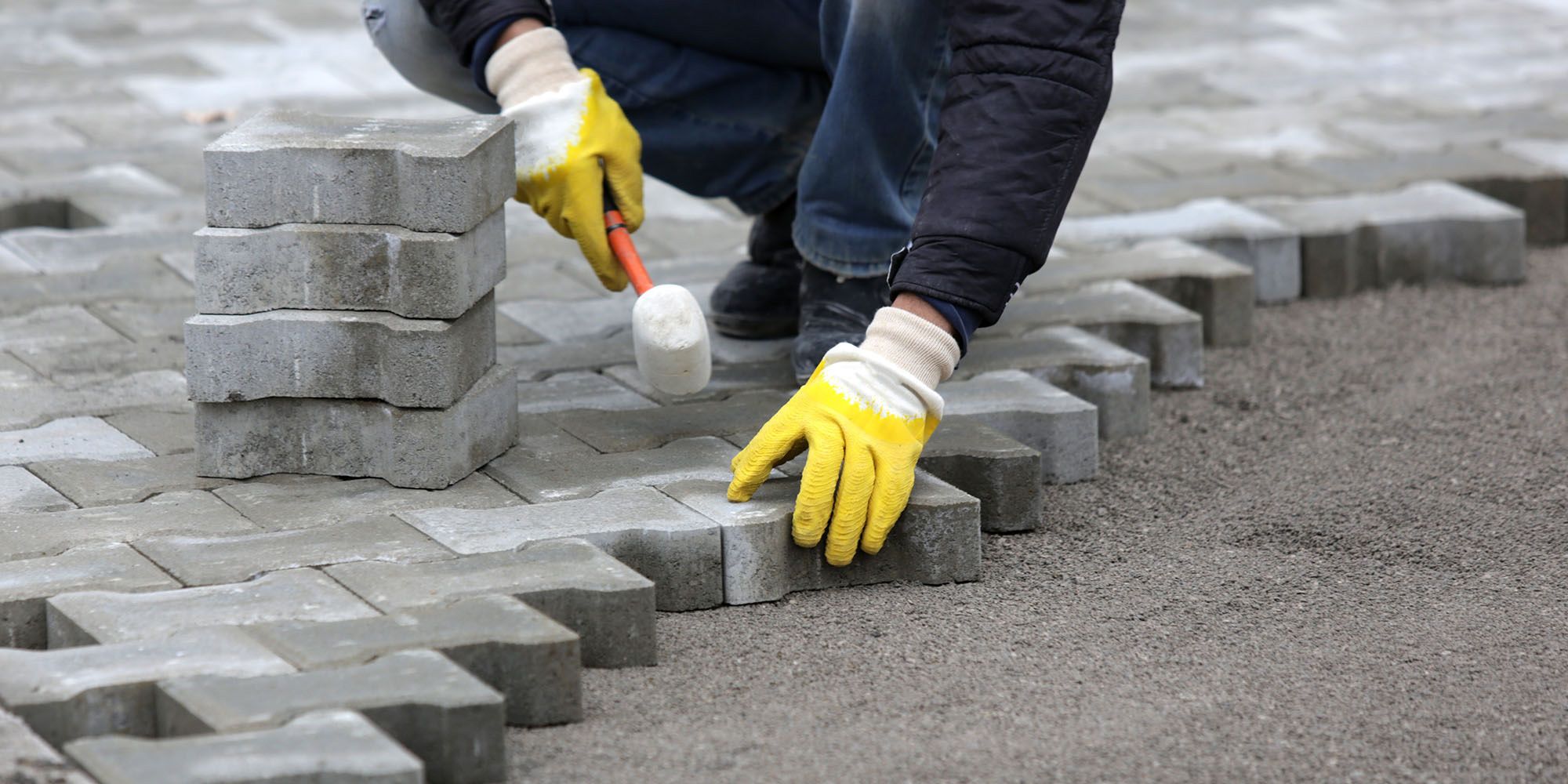 Bilde av en person som er i ferd med å legge belegningsstein.