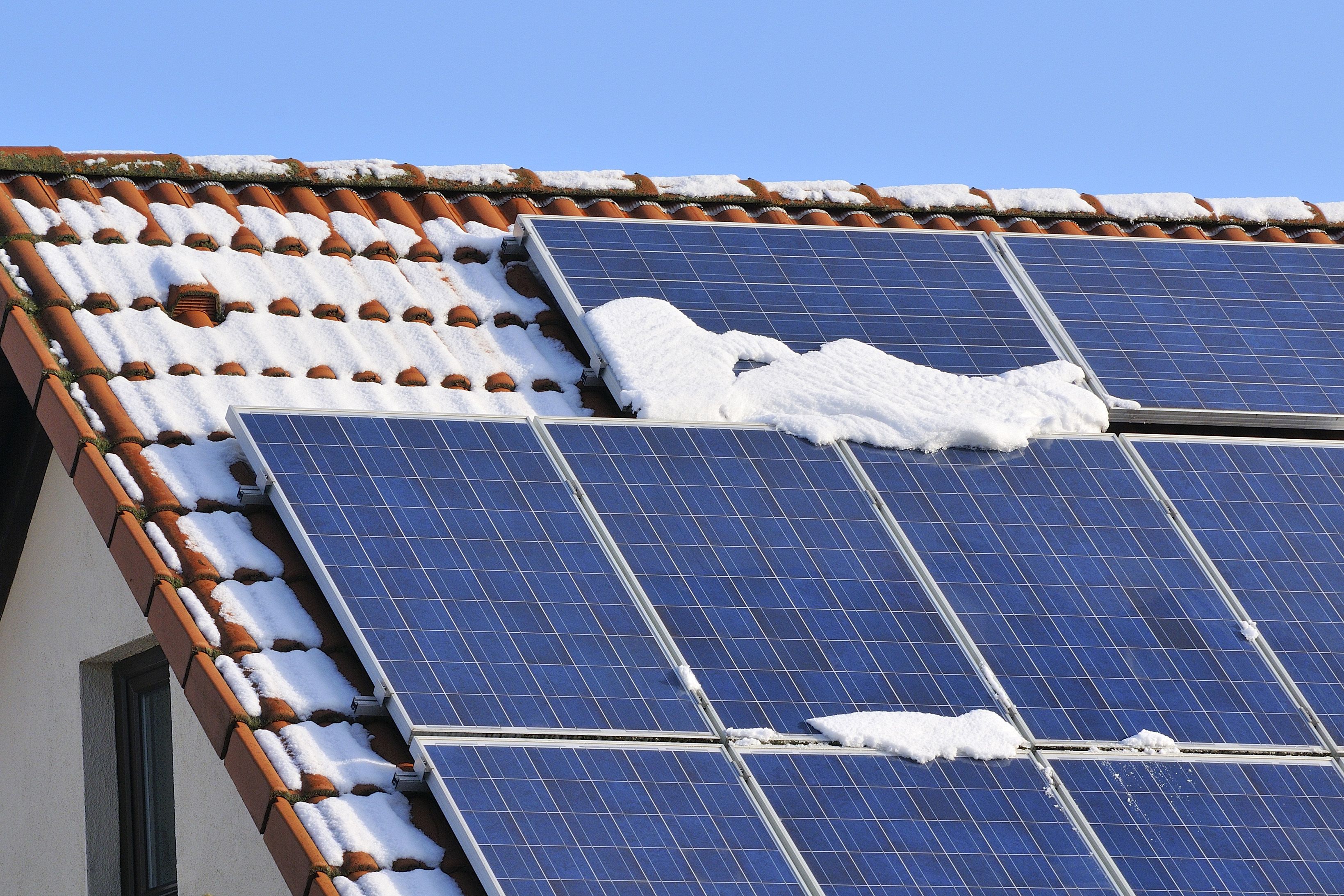 toit équipé de panneaux photovoltaïques et recouvert de neige