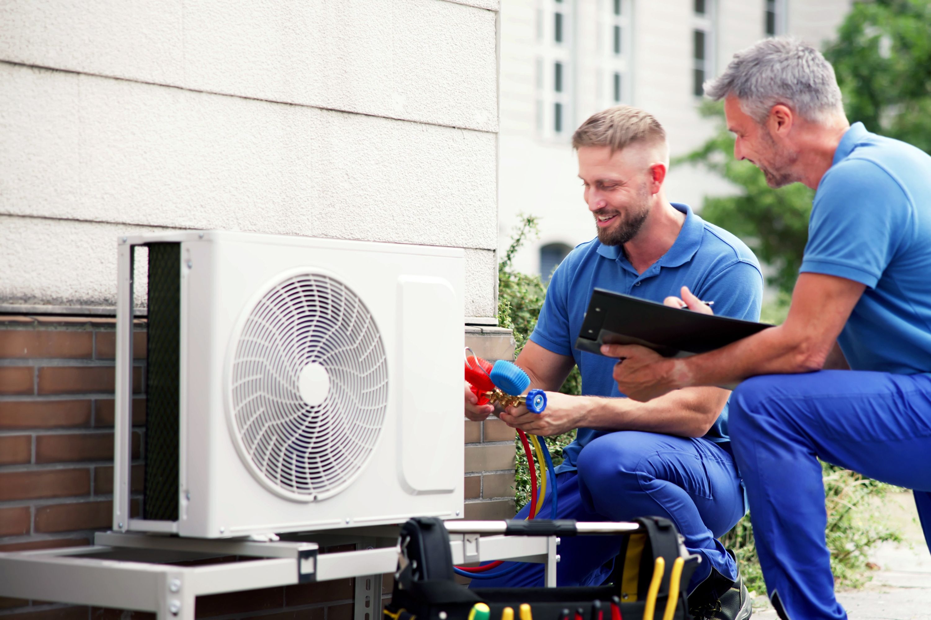 To arbejdere installerer en varmepumpe