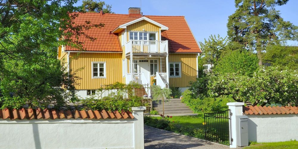 Ett gult hus som säljs med fast egendom inomhus och på tomten.