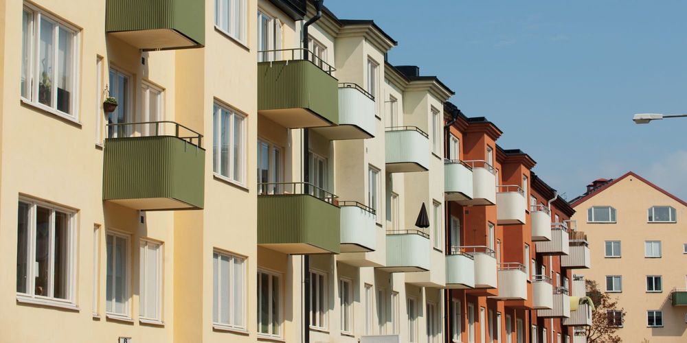 Fasaden av lägenheter i olika färger, med balkonger i plåt.