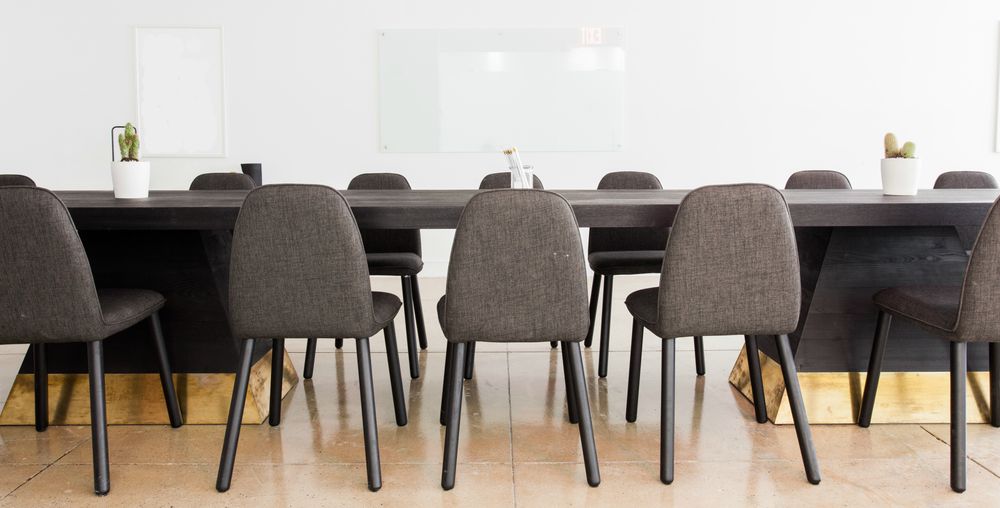 Ett mötesrum med ett avlångt bord och stolar.