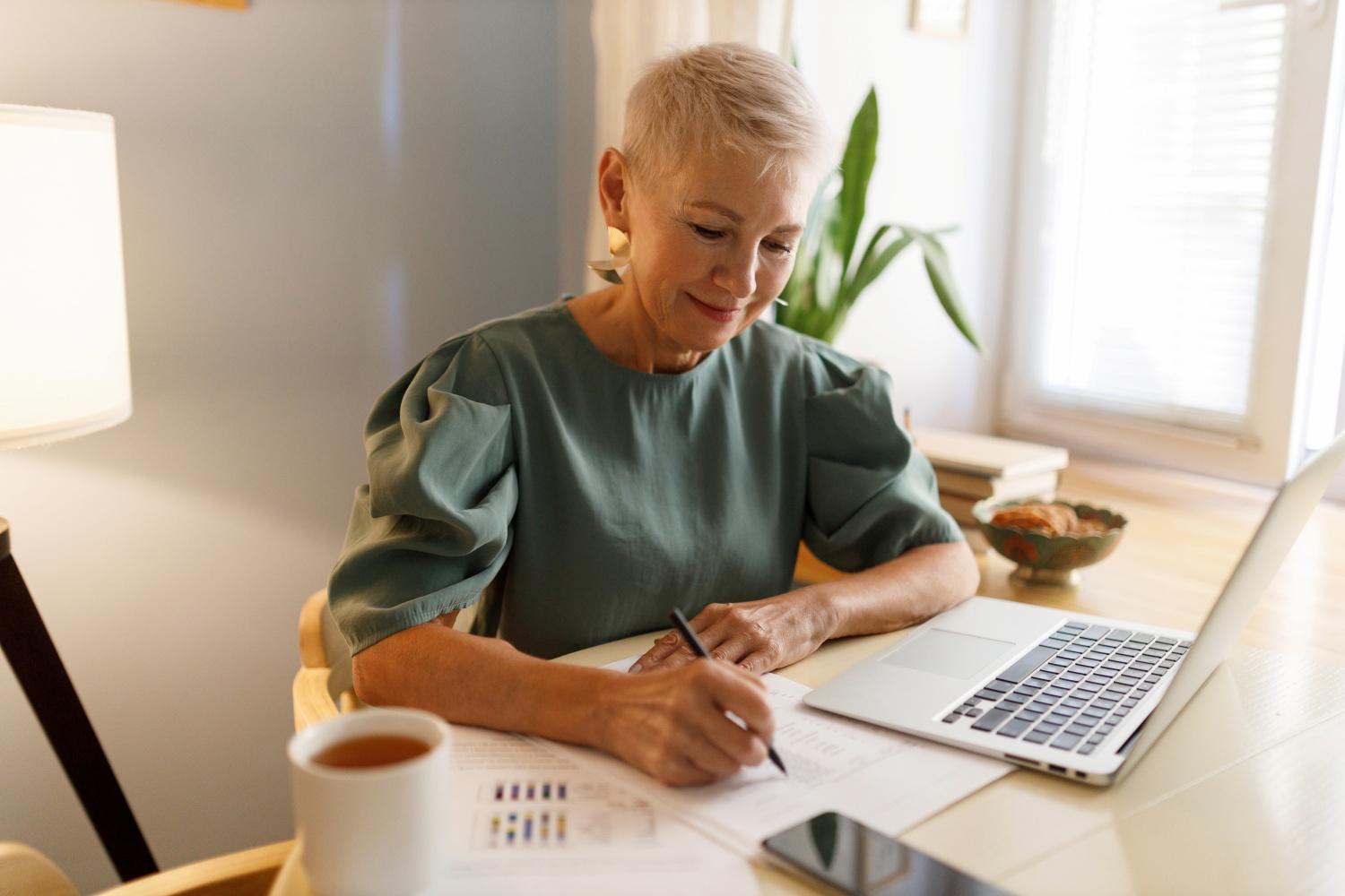 En kvinna i övre medelåldern jämför avtal från flera mäklare.