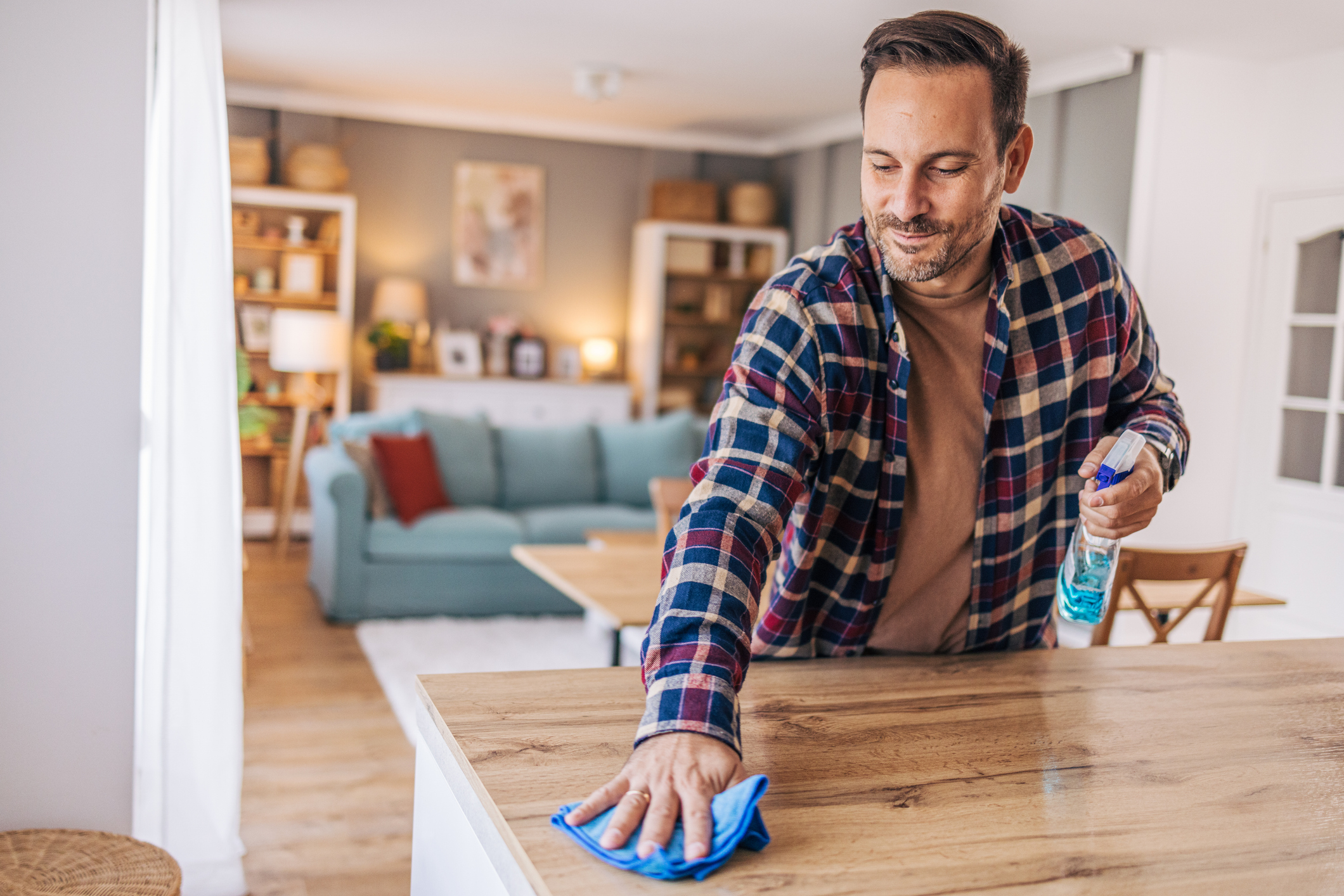 En man som städar ytor i köket.