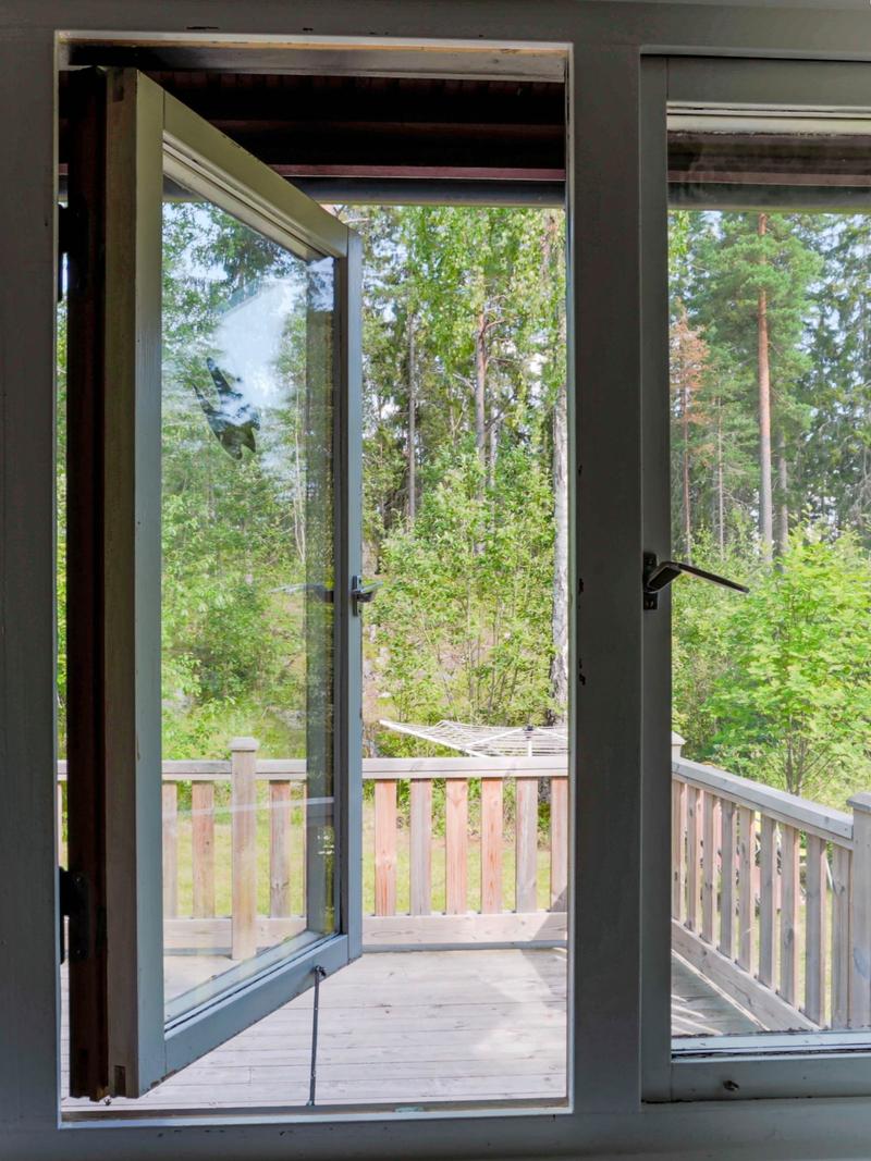 Ett vanligt fönster i en svensk villa står öppet, med tallar utanför.
