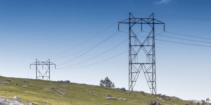 Bilde av strømmaster som strekker seg over et grønt landskap